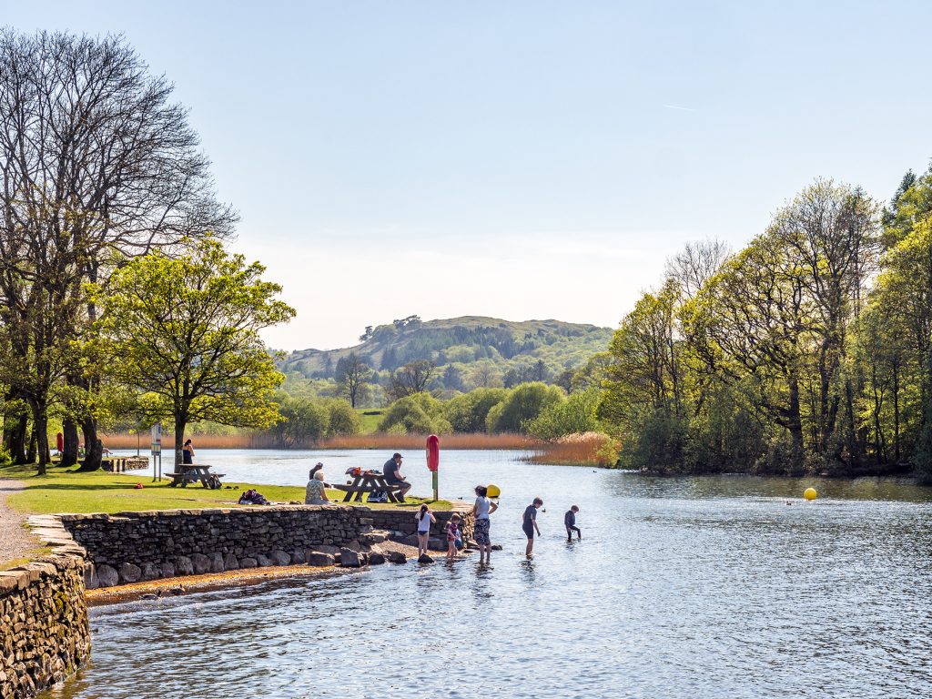Tourists enjoying the sunny weather by cooling off in the lake at Fell Foot